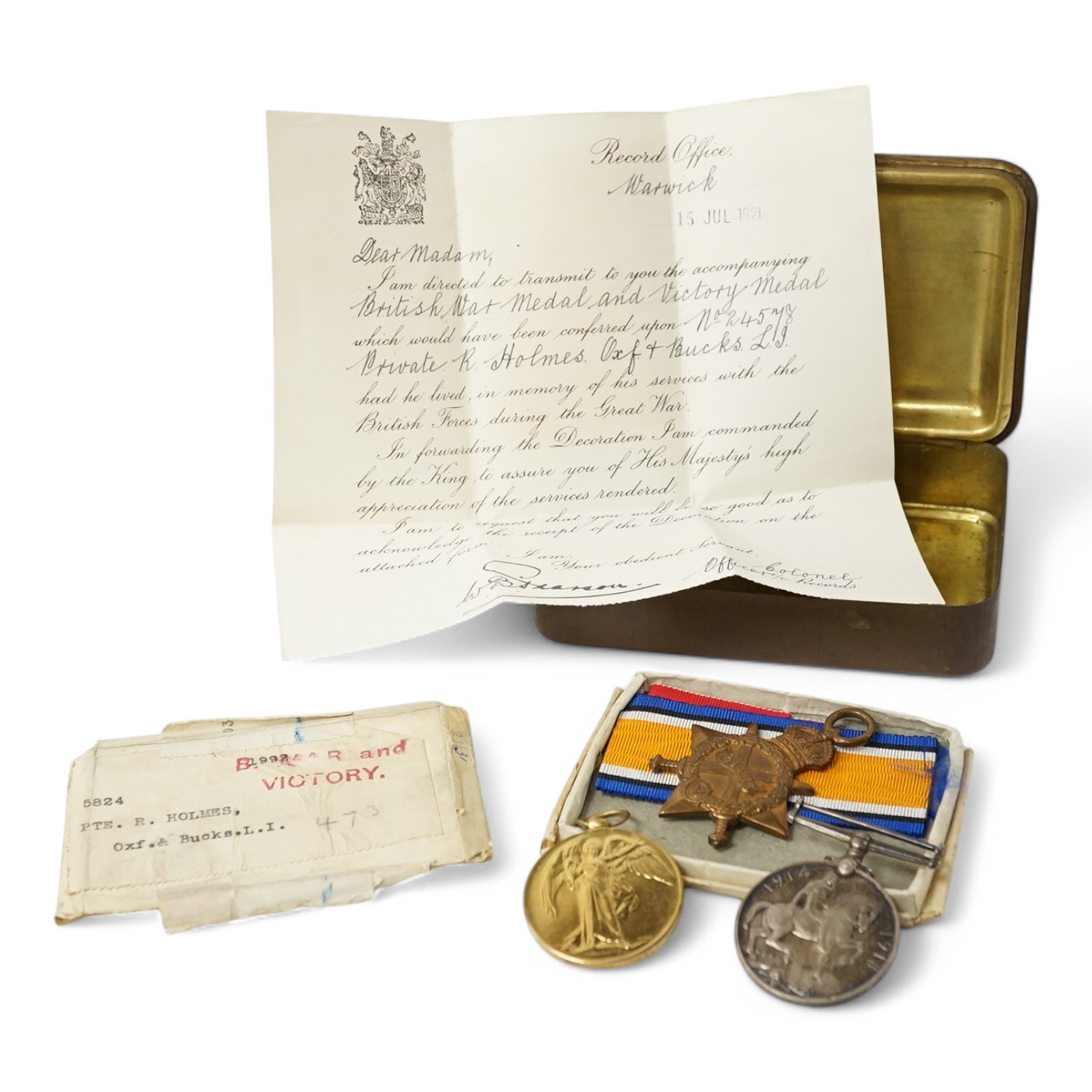 A posthumous First World War medal trio awarded to PTE. R. Holmes Oxf. & Bucks. L.I., together with the issuing letter, the remains of the original card box and a Princess Mary Christmas tin. Condition - fair.